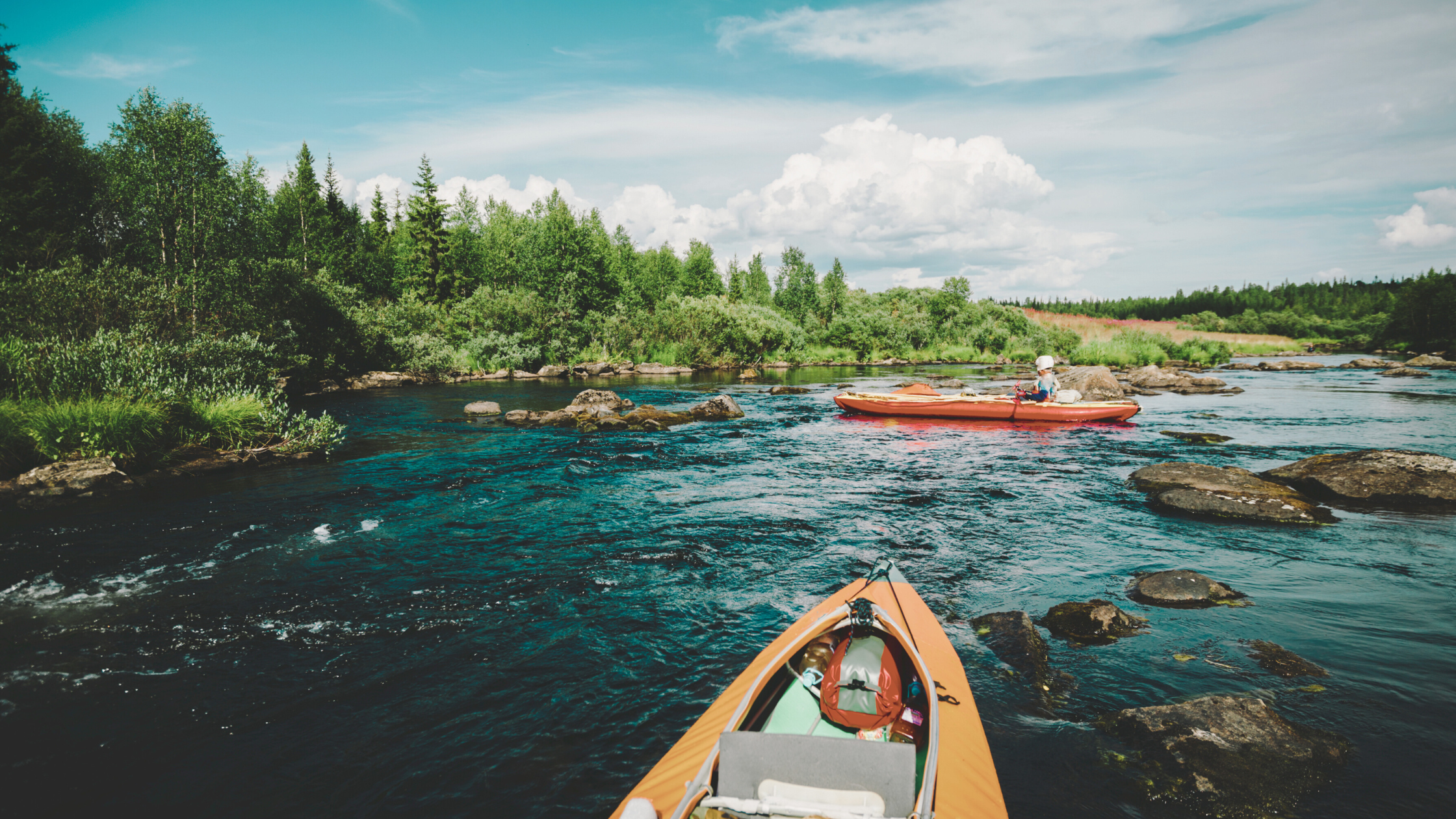Kayaks Navigating A River with Rocks